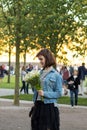 Young cute girl with flowers received the message or call on her