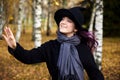Young cute girl in a hat, beautiful autumn day in the park. Festive season in October. Halloween witch hat Royalty Free Stock Photo