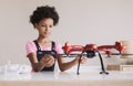 Young cute girl holding quadcopter. Child playing with drone at home.