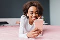 Young cute girl lying in bed, listening to music Royalty Free Stock Photo