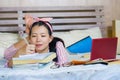 Young cute and happy nerdy Asian Korean student teenager girl in nerd glasses and hair ribbon studying at home bedroom sitting on