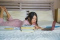 Young cute and happy nerdy Asian Korean student teenager girl in nerd glasses and hair ribbon studying at home bedroom sitting on Royalty Free Stock Photo