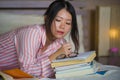 Young cute and happy nerdy Asian Korean student teenager girl in nerd glasses and hair ribbon studying at home bedroom sitting on Royalty Free Stock Photo