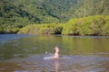 Young cute little girl playing in the water in a beautiful river on a sunny summer day Royalty Free Stock Photo