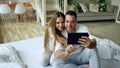 Closeup of Young cute and loving couple having video chat holding smartphone and chatting to friends sitting in bed at Royalty Free Stock Photo