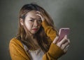 Young cute and sad Asian Korean girl feeling broken heart and desperate holding mobile phone suffering relationship break up Royalty Free Stock Photo