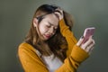 Young cute and sad Asian Korean girl feeling broken heart and desperate holding mobile phone suffering relationship break up Royalty Free Stock Photo