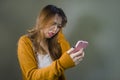 Young cute and sad Asian Korean girl feeling broken heart and desperate holding mobile phone suffering relationship break up Royalty Free Stock Photo