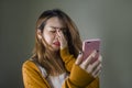 Young cute and sad Asian Korean girl feeling broken heart and desperate holding mobile phone suffering relationship break up Royalty Free Stock Photo