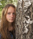 Young cute teen girl with long hair portrait near the tree. Royalty Free Stock Photo