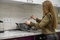 Young cute woman cooking at purple and white modern kitchen furniture Royalty Free Stock Photo