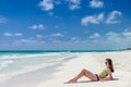 Young cute woman lying and getting some sun at tropical sandy beach