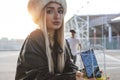 Young cute woman while showing a mobile phone inside a metal cage Royalty Free Stock Photo