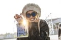 Young cute woman while showing a mobile phone inside a metal cage Royalty Free Stock Photo