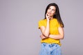 Young cute woman thinking about something on the gray background Royalty Free Stock Photo