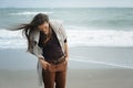 Young cute woman walking by a sea beach, windy day, autumn fashion, healthy lifestyle Royalty Free Stock Photo