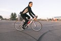 Young cyclist rides in a car parking lot for a bike