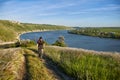 Young cyclist riding mountain bike uphill along a country road above river. Royalty Free Stock Photo