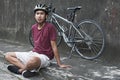 Young Cyclist Sitting At The Roadside