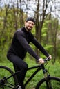 Young cyclist standing on back wheel on trial bicycle. Sportsman rider making acrobatic stunt on the edge of big boulder on the