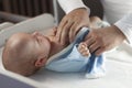 Young dad changes the diaper and clothes to his newborn small child. Selective focus.
