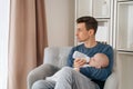 Young dad feeding his newborn baby with bottle of milk at home Royalty Free Stock Photo