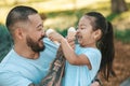 Young dad and his daughter eating ice-cream and looking enjoyed