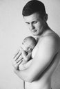 A young dad holds his newborn baby in his arms. Royalty Free Stock Photo