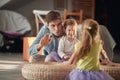 A young Dad at home teaching his daughters how to drum on the furniture. Family, home, playing, togetherness Royalty Free Stock Photo