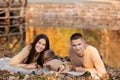 Young dad and mom with baby girl and little son having fun on blanket near pond in autumn park on sunny day. happy family concept Royalty Free Stock Photo