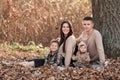 Young dad and mom with baby girl relaxing on blanket in autumn park on sunny day. happy family concept. mother`s, father`s, baby Royalty Free Stock Photo