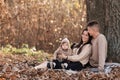 Young dad and mom with baby girl relaxing on blanket in autumn park on sunny day. happy family concept. mother`s, father`s, baby Royalty Free Stock Photo