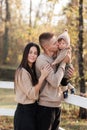 Young dad and mom with baby girl walking in autumn park on sunny day. happy family concept. mother`s, father`s, baby`s day Royalty Free Stock Photo