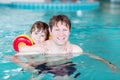 Young dad teaching his little son to swim indoors Royalty Free Stock Photo