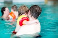 Young dad teaching his little son to swim indoors Royalty Free Stock Photo