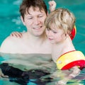 Young dad teaching his little son to swim indoors Royalty Free Stock Photo