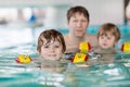 Young dad teaching his two little sons to swim indoors Royalty Free Stock Photo