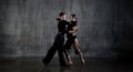 The young dance ballroom couple in black dress dancing in sensual pose on studio background. Professional dancers Royalty Free Stock Photo