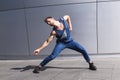 Young dancer doing dance motion on gray background