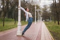 Young dancer holding onto a light pole in the park Royalty Free Stock Photo