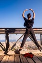 Young dancer jumping in mid-air on the bridge, urban landscape in the background Royalty Free Stock Photo