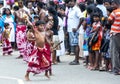 A young dancer performs in front of a large crowd during the Hikkaduwa Perahara in Sri Lanka.