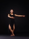 A young dancer is standing in the dance, the pivot position for rotation. On a black background.