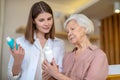 Young dark-haired cosmetologist demonstrating new cosmetic products to a female customer Royalty Free Stock Photo