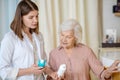 Young dark-haired cosmetologist demonstrating new cosmetic products to a female customer Royalty Free Stock Photo