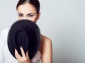 Young dark-haired girl hiding her face behind the hat. Royalty Free Stock Photo