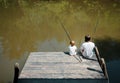 A young dark-haired man and a blond boy dressed in the white t-s Royalty Free Stock Photo