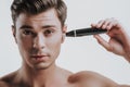 Young dark haired man using trimmer for his ear Royalty Free Stock Photo