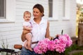 A young dark-haired woman with baby and peonies Royalty Free Stock Photo