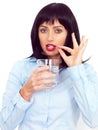 Young Dark Haired Woman holding a Glass of Water Taking Medicine Royalty Free Stock Photo